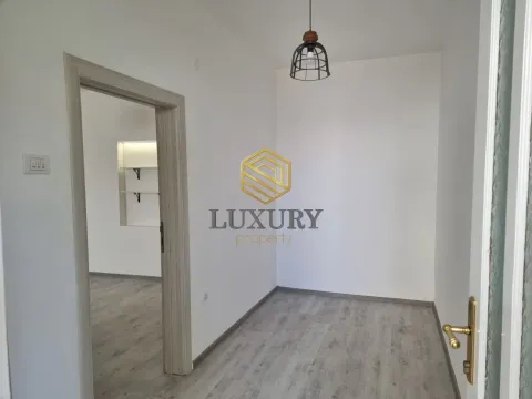 Empty bright room with laminate flooring and a view into the hallway. - image 5