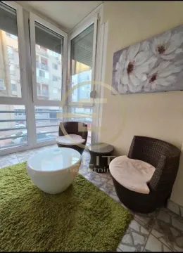 Zastakljena terasa opremljena pletenim foteljama, stočićem i tepihom. - image 10