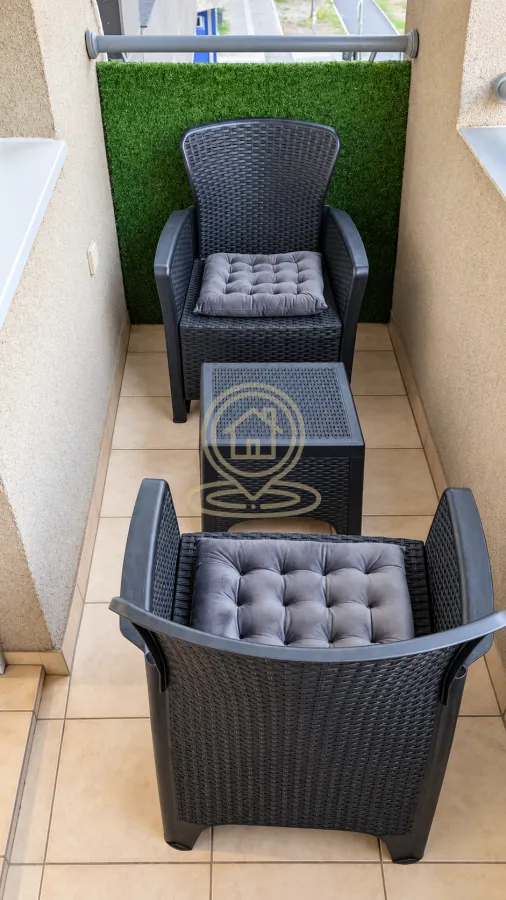 Small furnished balcony with two armchairs and a small table.