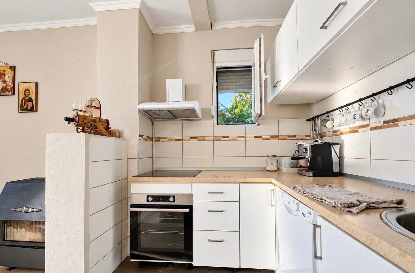 Smaller bright kitchen with white cabinets and built-in appliances.