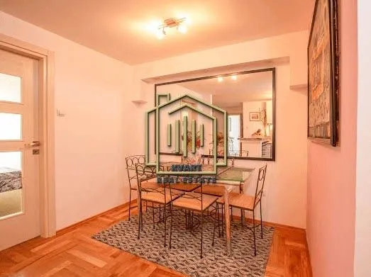Dining area with a table, chairs, and a wall mirror.
