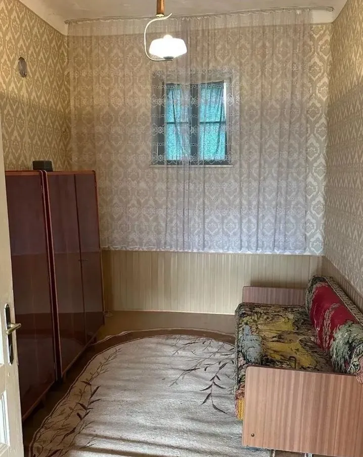 Manja opremljena soba sa krevetom i ormarima.