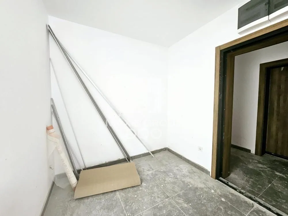 Empty room with floor tiles and construction material.
