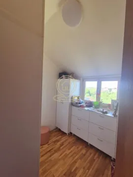 Manja soba sa drvenim podom, belom komodom i prozorom. - image 13