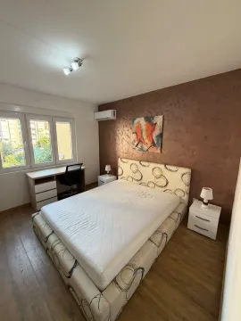 Furnished bedroom with a double bed, desk, and a window. - image 13