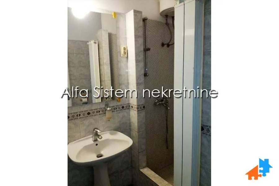 Smaller bathroom with a washbasin, mirror and shower cabin.