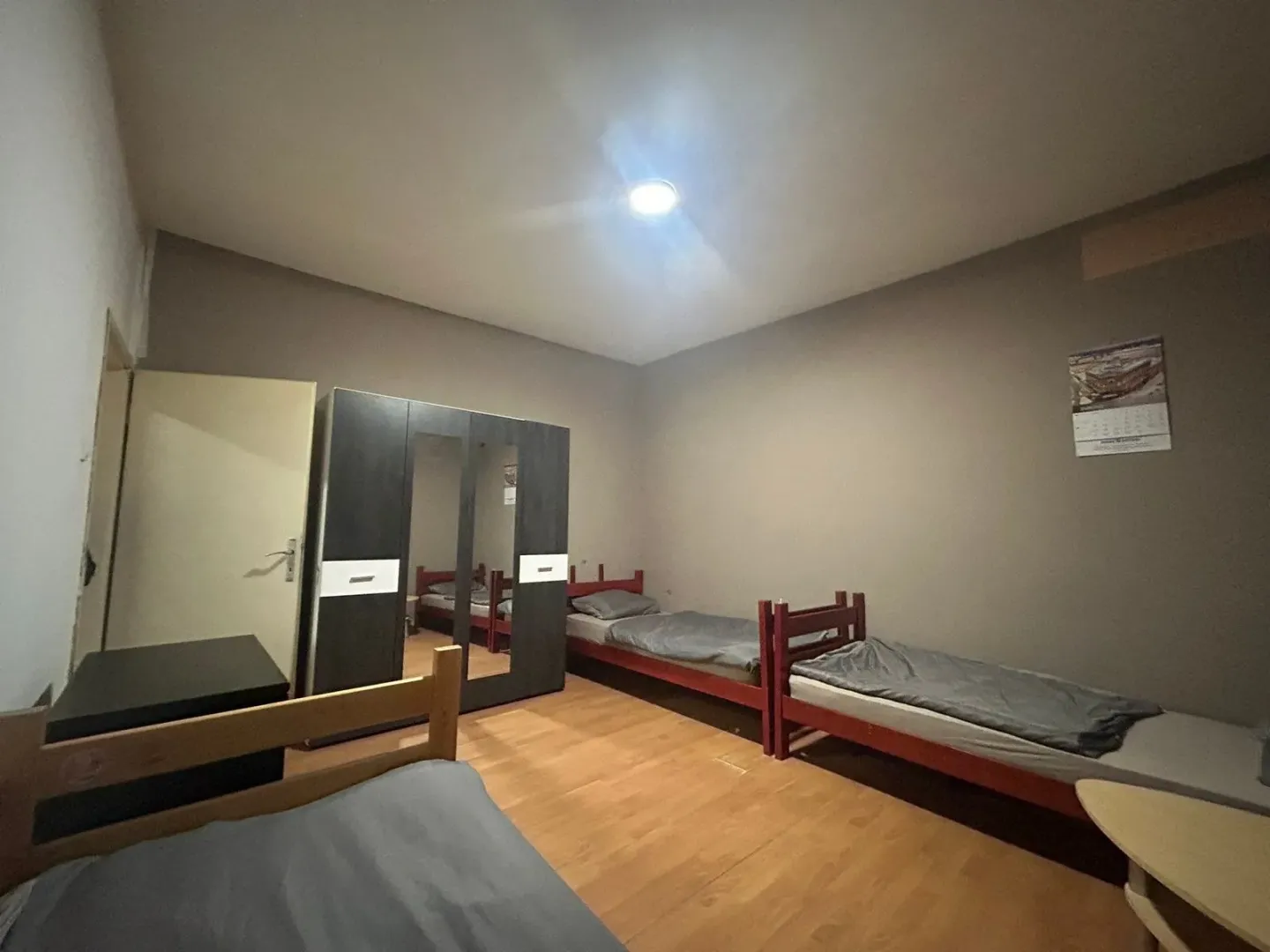 Bedroom with multiple beds and a wardrobe.