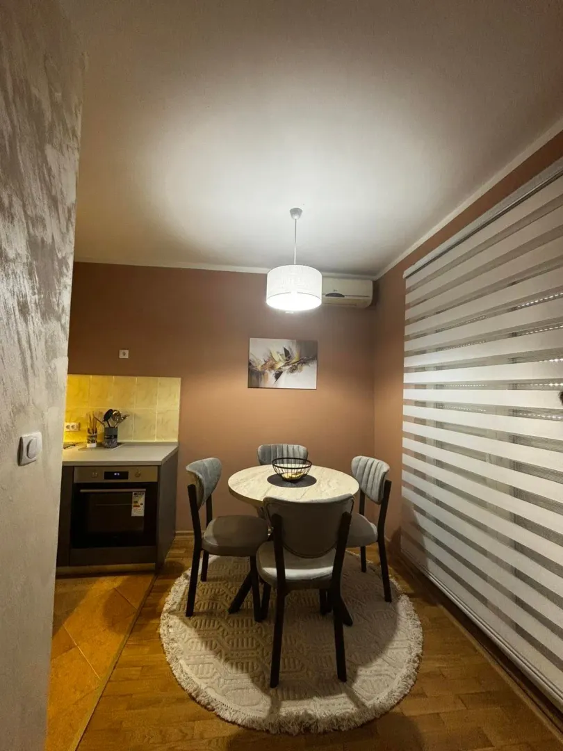 Dining area with a round table and chairs next to a small kitchen.