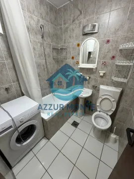 Smaller bathroom with a bathtub, washbasin, toilet, and washing machine. - image 7