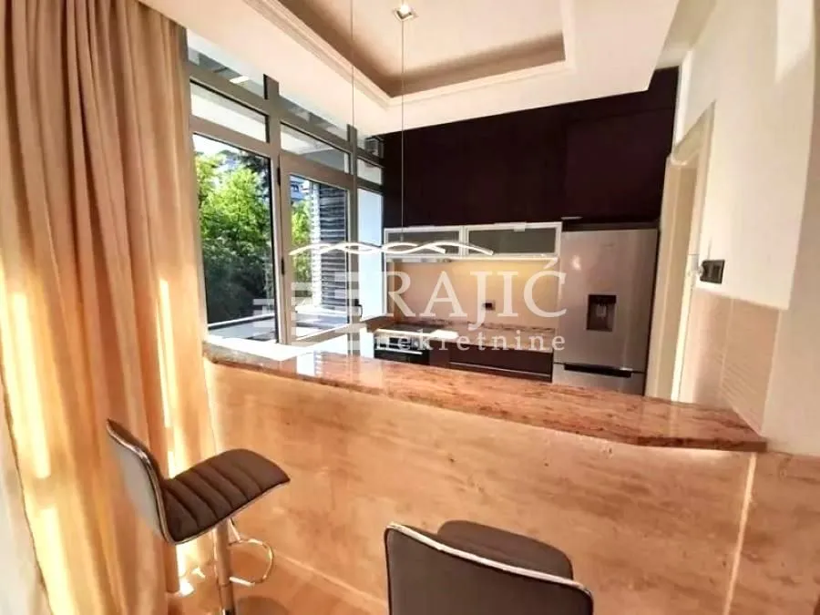 Modern kitchen with a bar counter and dining table.