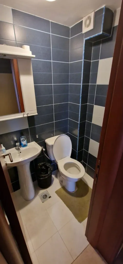 Manje kupatilo sa lavaboom, wc šoljom i zidnim pločicama.