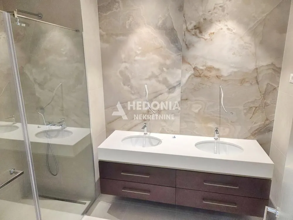 Modern bathroom with a double sink and a walk-in shower.