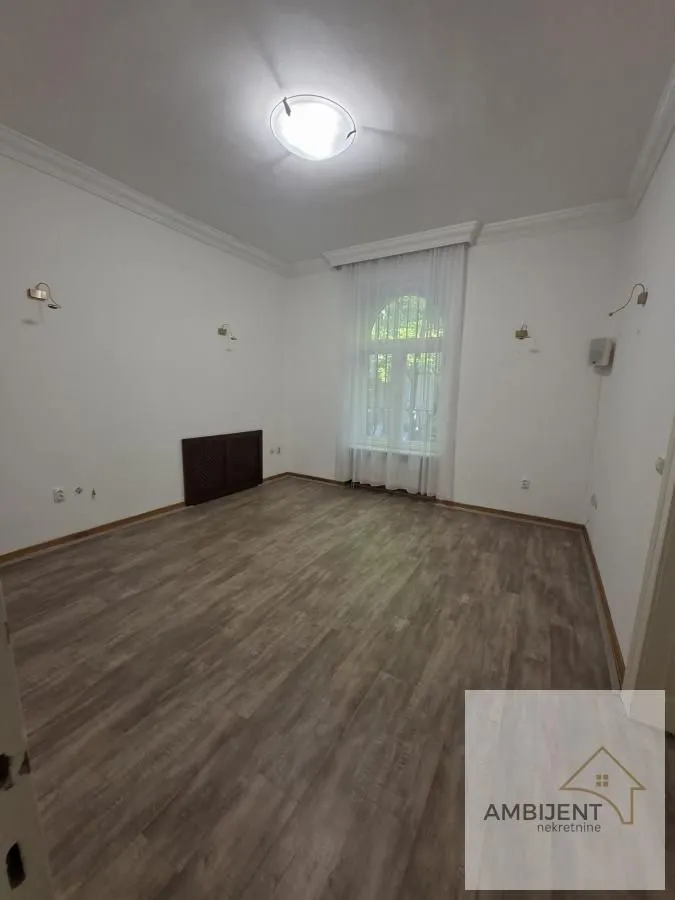 Empty room with laminate flooring and white walls.
