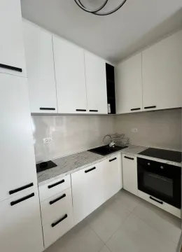 Moderna kuhinja sa bijelim elementima i crnim detaljima. - image 5