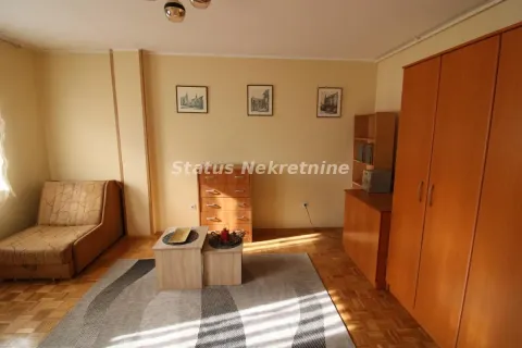 Dnevna soba sa garniturom za sedenje, drvenim ormarima i laminatnim podom. - image 2