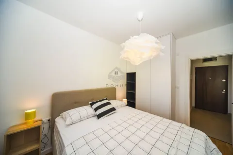 Furnished bedroom with a double bed, a white wardrobe, and a bedside table. - image 6