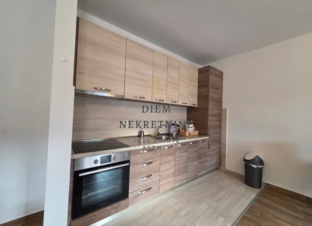Moderna kuhinja sa drvenim elementima i ugradnom tehnikom.
