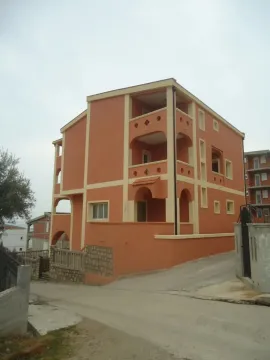 Vanjski izgled višespratne narandžaste kuće sa balkonima. - image 8