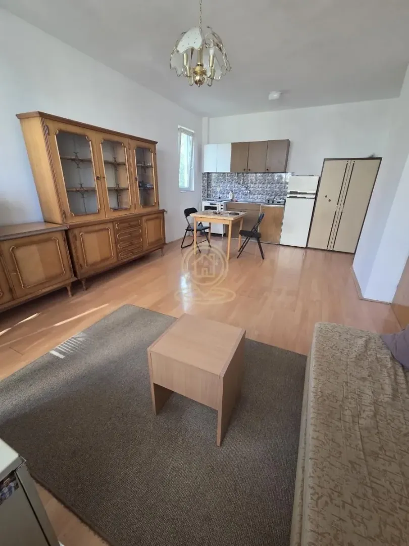 Living room with a dining table and kitchen area in the background.