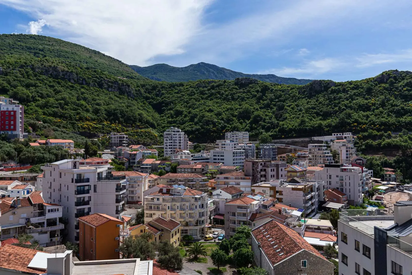 Pogled na gradsko naselje i brda u pozadini.