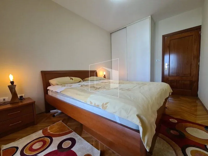 Bedroom with a double bed, fitted wardrobe and parquet flooring.