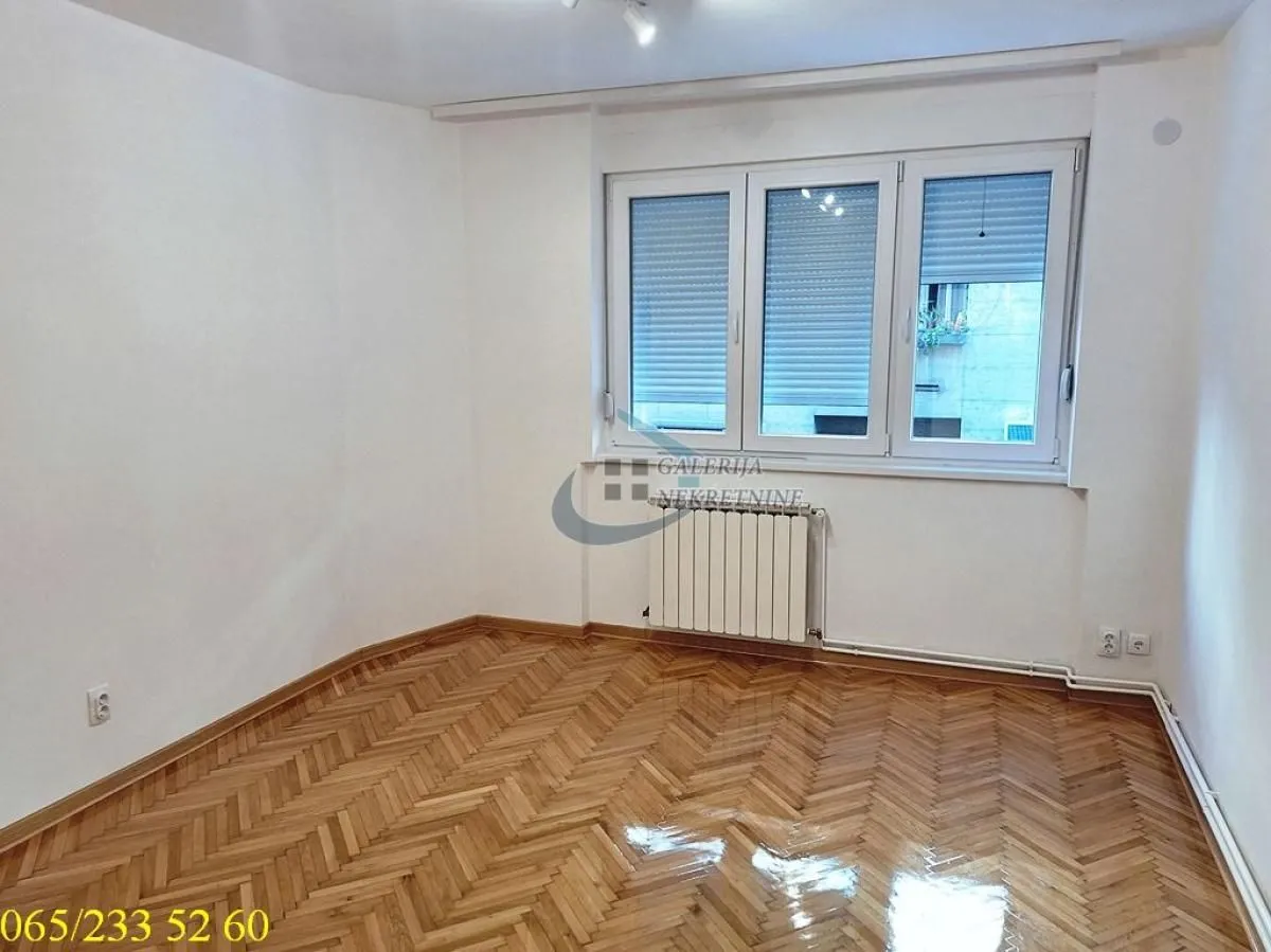 Empty room with hardwood flooring and white walls.
