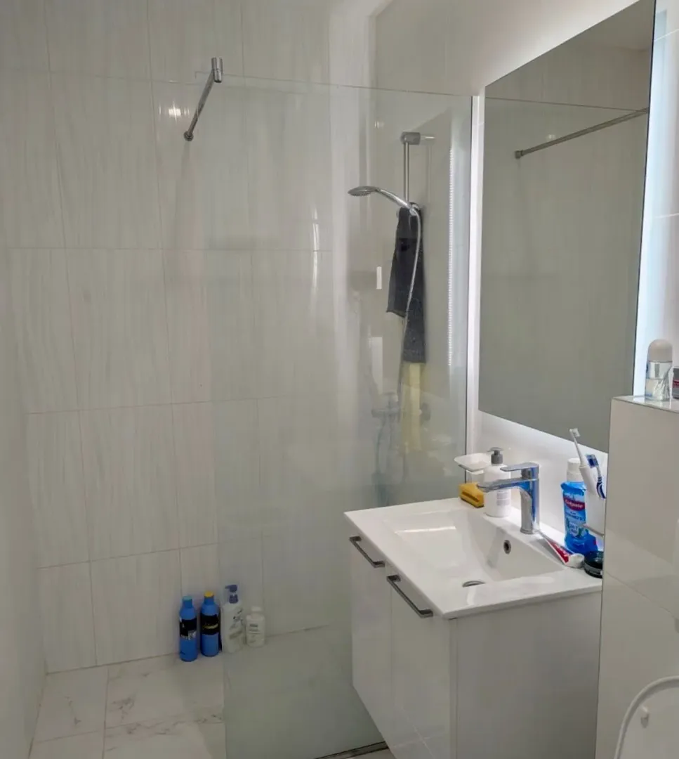 Moderne kupatilo sa umivaonikom i tuš kabinom.