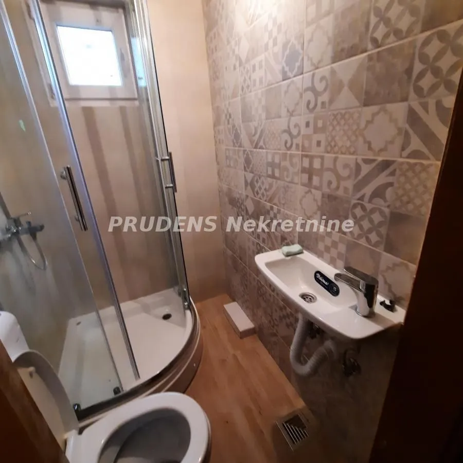 Smaller bathroom with a shower cabin and decorative tiles.