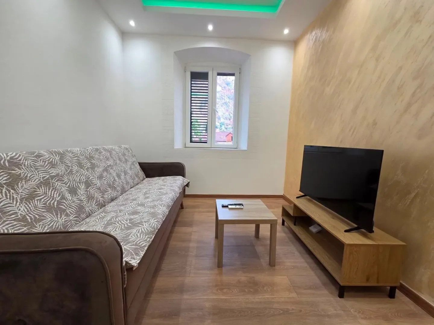 Living room with sofa, coffee table, and TV.