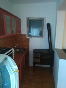 Jednostavna kuhinja sa drvenim elementima i peći na drva. - image 4