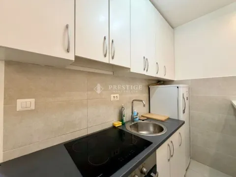 Small kitchen with white cabinets and a built-in cooktop. - image 5
