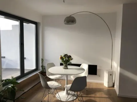 Small dining table with four chairs and a decorative floor lamp near the window. - image 6