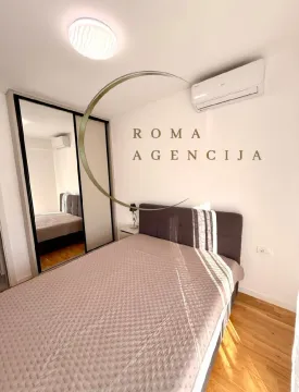 Furnished bedroom with a double bed, wardrobe, and air conditioning. - image 6