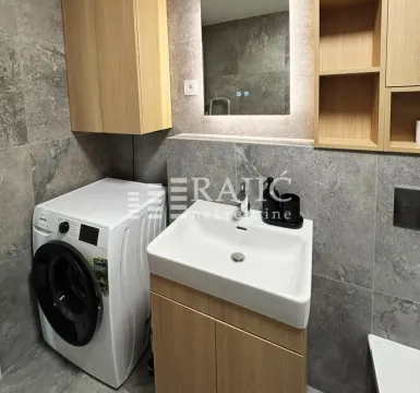 Modernly equipped bathroom with a washbasin and washing machine. - image 13