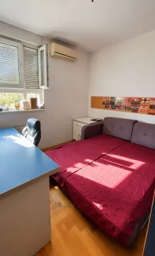 Manja spavaća soba sa krevetom, pisaćim stolom i klima uređajem. - image 4