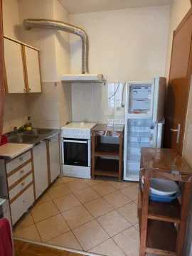 Manja kuhinja opremljena osnovnim elementima, šporetom i frižiderom. - image 2