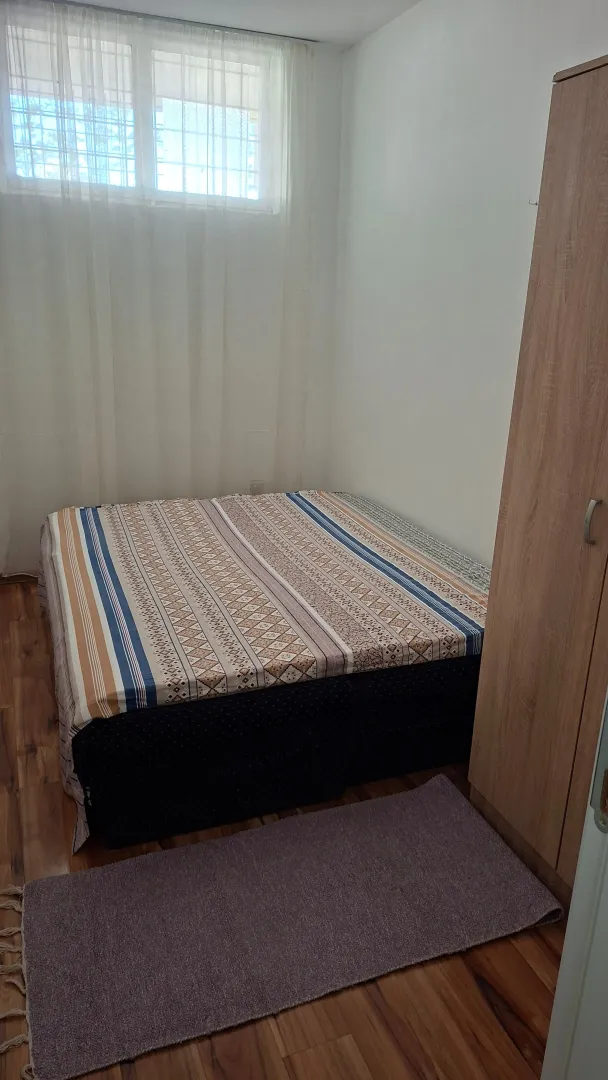 Furnished bedroom with a bed and wardrobe.