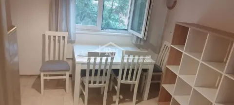Dining area with a white table, chairs, and a shelving unit by the window. - image 6
