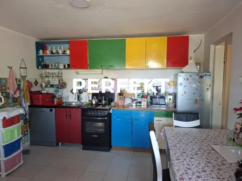Starija kuhinja sa šarenim elementima i trpezarijskim stolom. - image 7