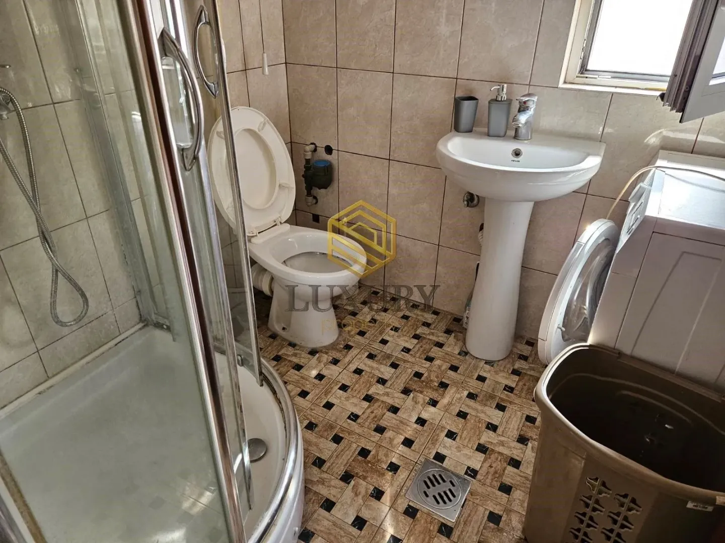 Manje kupatilo sa tuš kabinom, umivaonikom i wc šoljom.