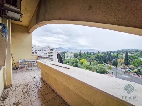 Prostrana natkrivena terasa sa garniturom za sjedenje i pogledom na grad. - image 3