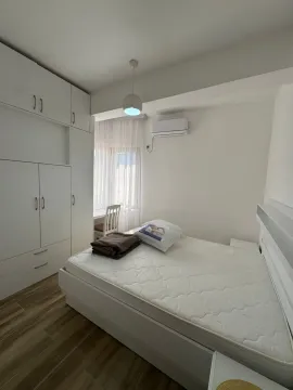 Furnished bedroom with a double bed, large wardrobe and air conditioning unit. - image 8