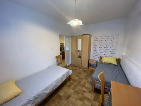 Spavaća soba sa dva kreveta, ormarom i stolom. - image 4