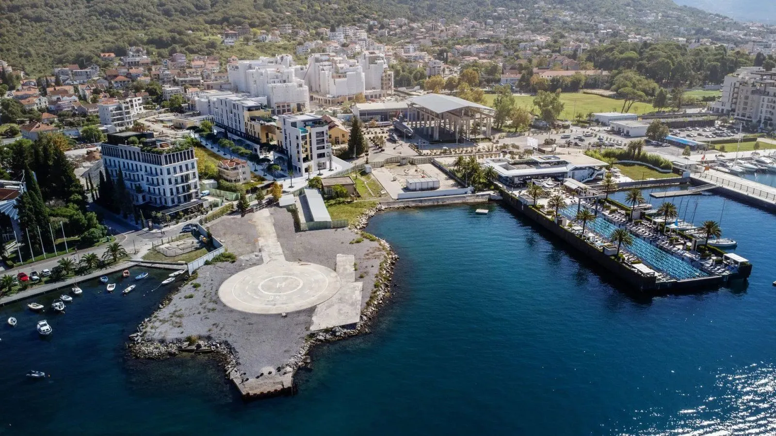 Pogled iz vazduha na obalu sa marinom, zgradama i okolinom.