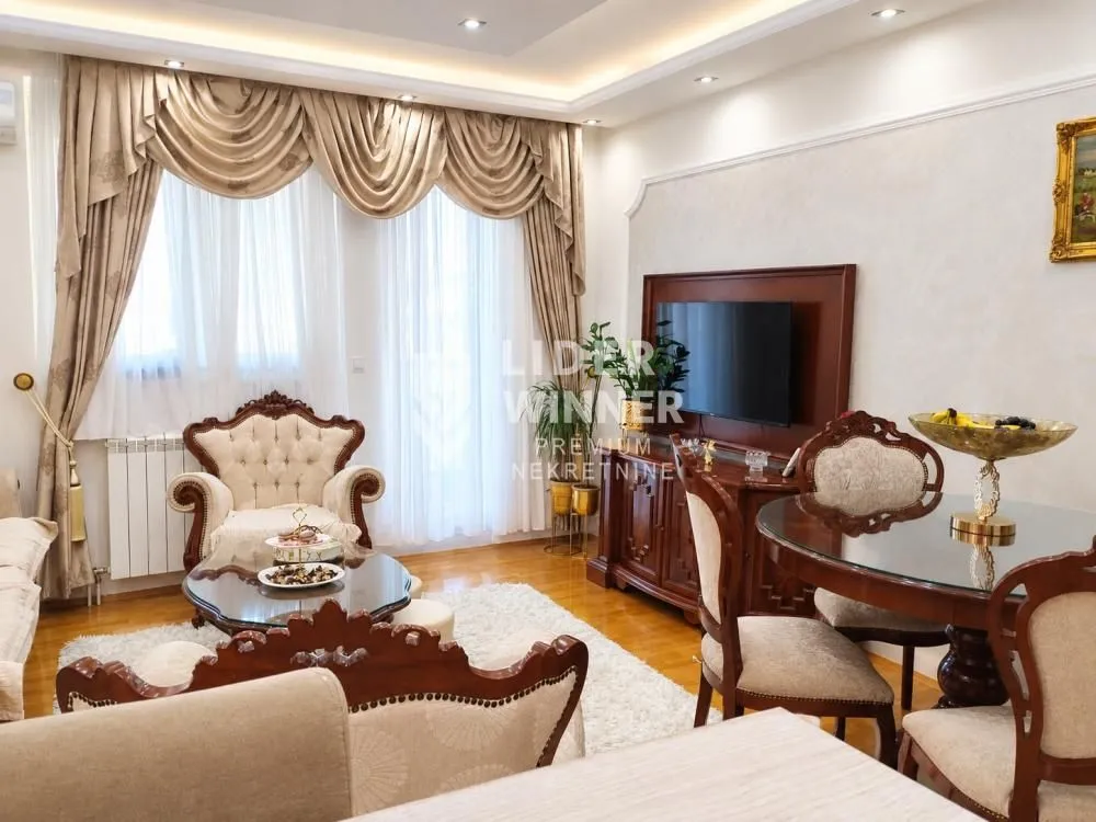 Living room with seating furniture, dining table and TV.