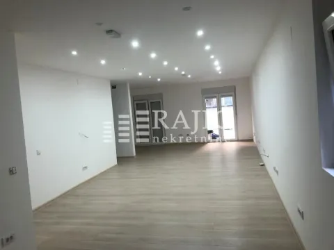 Prazan i svetao dnevni boravak sa laminatom na podu i ugradnom rasvetom. - image 4