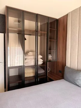 Modern wardrobe with glass doors next to the bed in the bedroom. - image 5