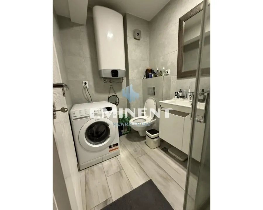 Bathroom equipped with sanitary ware, a shower cabin, and a washing machine.
