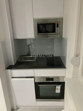 Manja bela kuhinja sa ugradnom rernom, ploçom, sudoperom i mikrotalasnom pećnicom. - image 3