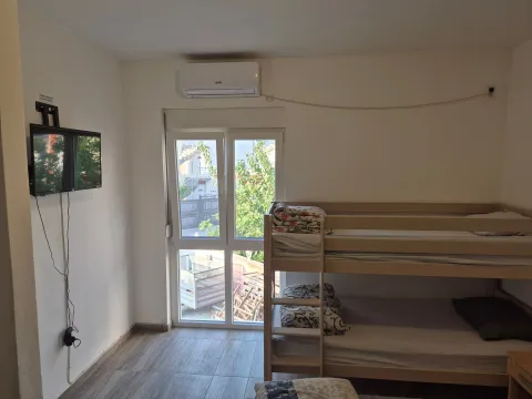 Bedroom with a bunk bed, a television, and an air conditioning unit. - image 5